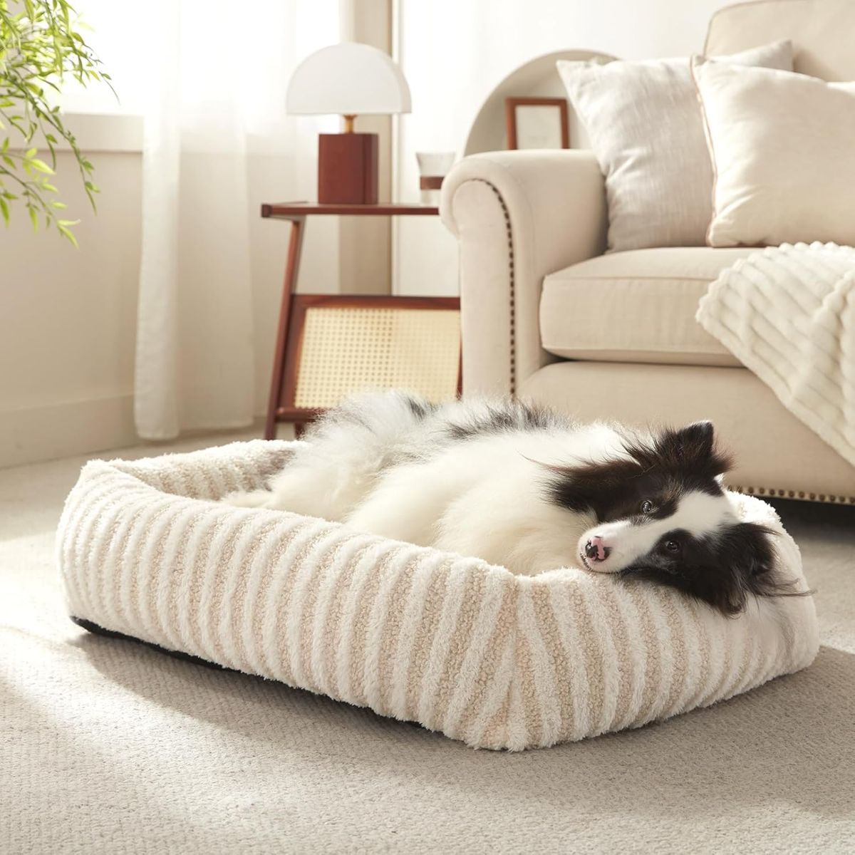 Soft striped dog bed in white with a dog resting comfortably, set in a cozy home environment.