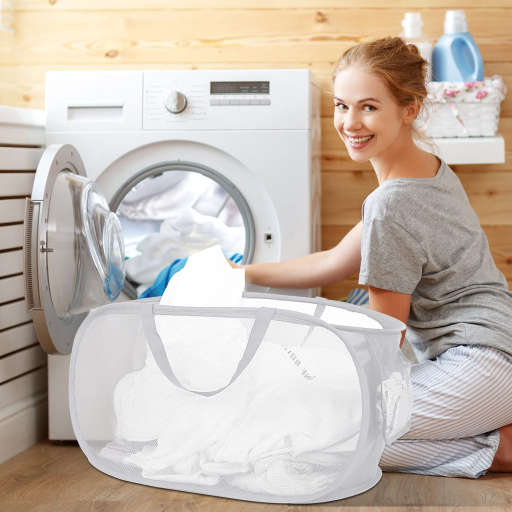Two collapsible laundry hampers in a laundry setting, one filled with clothes, featuring carry handles and a mesh design.