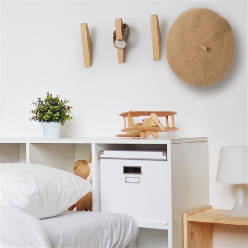 Wood wall hooks mounted on a wall with a plant and decorative items, showcasing Northlane Living's 4 Pack Wood Wall Hooks.