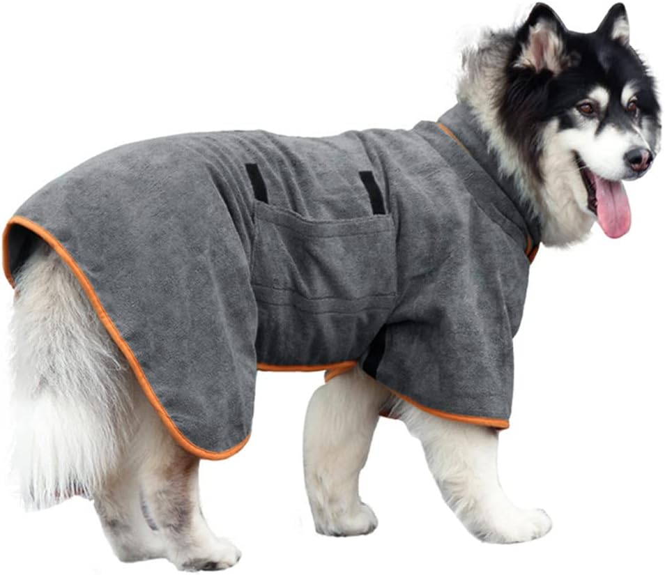 Grey dog bathrobe with orange piping, adjustable strap, and pockets, worn by a dog outdoors.
